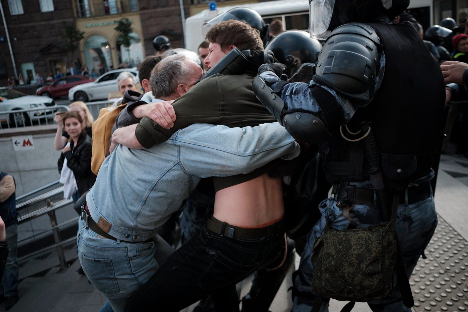 Father holds his son during protests in Moscow